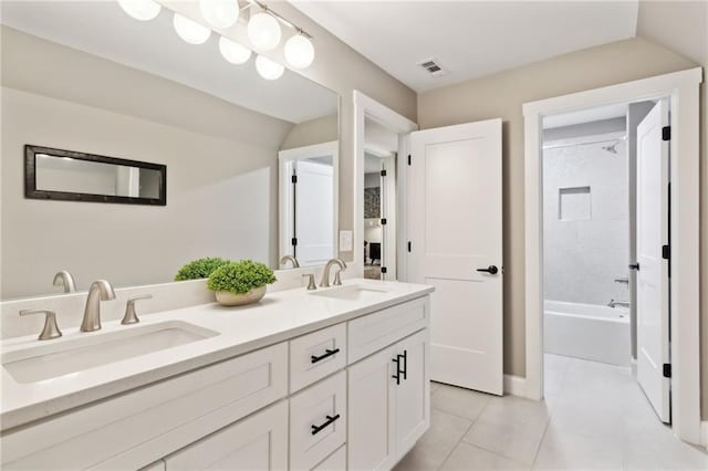 bathroom featuring vanity, lofted ceiling, tile patterned floors, and tiled shower / bath