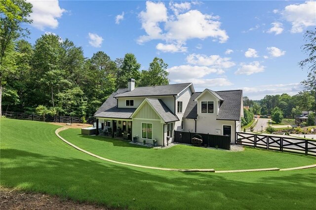 rear view of property with a yard