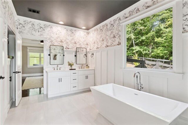 bathroom featuring vanity, a tub to relax in, and a wealth of natural light