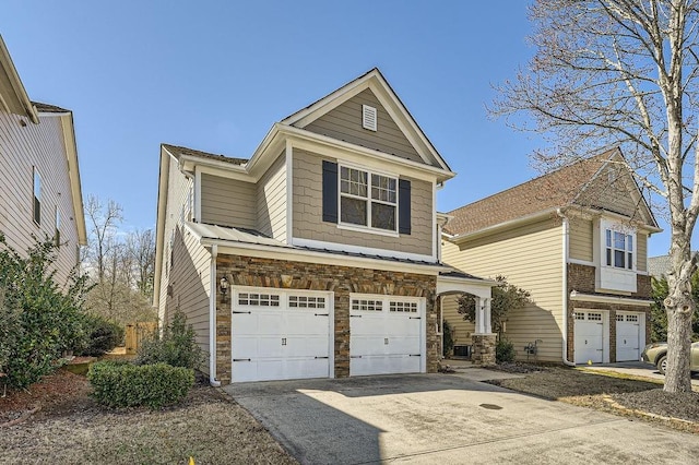 view of front of home with an attached garage, stone siding, and driveway