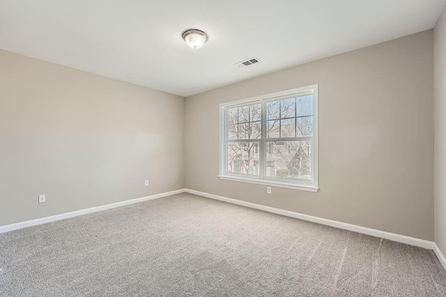 carpeted empty room featuring visible vents and baseboards