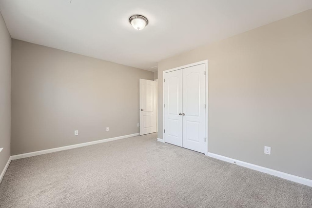 unfurnished bedroom featuring a closet, baseboards, and carpet flooring