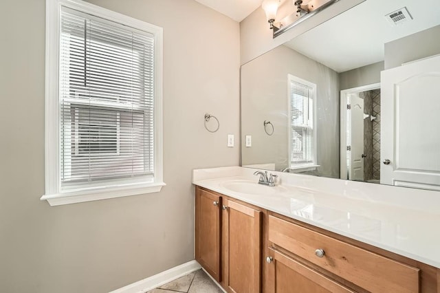 bathroom with visible vents, vanity, baseboards, and tile patterned floors