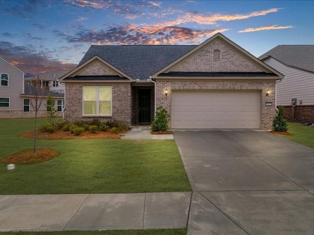 view of front of house with a garage, brick siding, driveway, and a front lawn