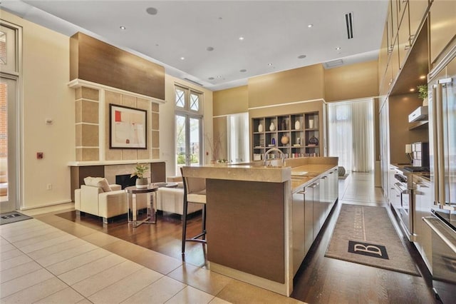 1820 Peachtree St NW Unit 1008, Atlanta, GA 30309 - kitchen featuring an island with sink, tile patterned floors, open floor plan, a sink, and a fireplace