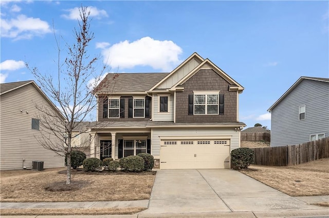 craftsman-style home featuring concrete driveway, an attached garage, fence, central AC, and board and batten siding