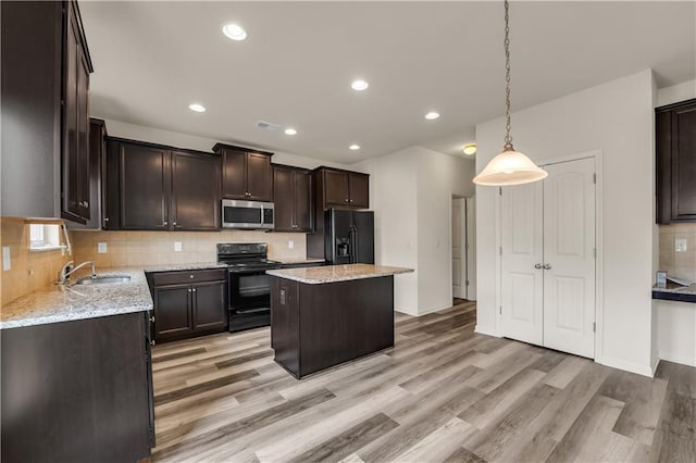 kitchen featuring a sink, dark brown cabinets, decorative backsplash, black appliances, and light wood finished floors