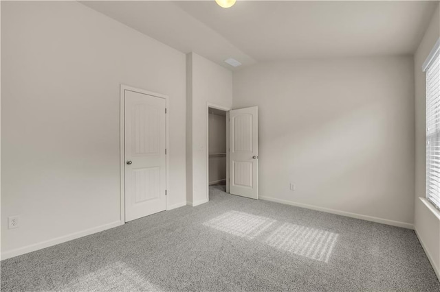 unfurnished bedroom with baseboards, vaulted ceiling, and carpet flooring