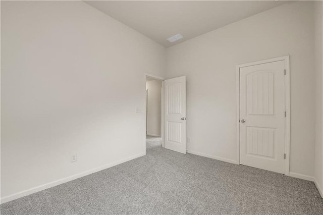 carpeted spare room with visible vents and baseboards