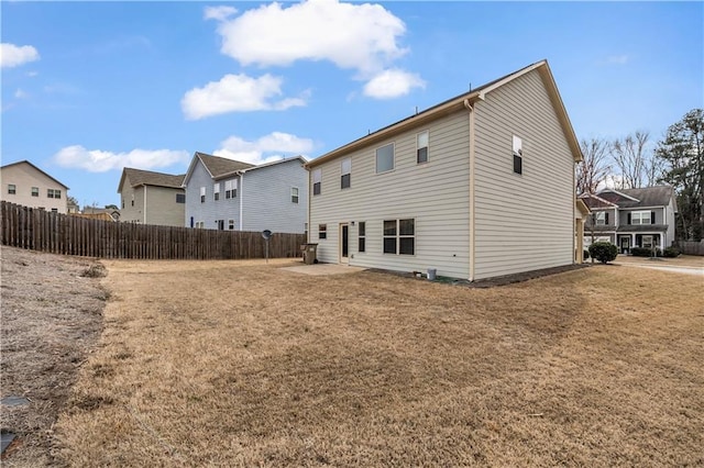 rear view of house with a patio, a lawn, fence, and a residential view