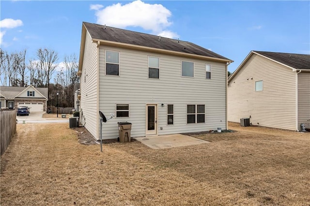 rear view of property featuring fence, central AC unit, a lawn, and a patio