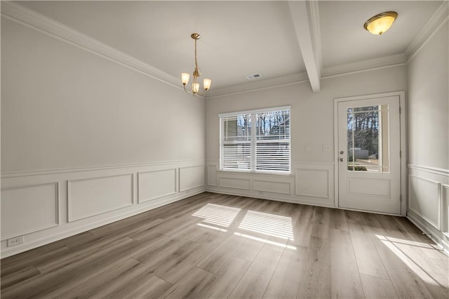 unfurnished dining area featuring wood finished floors, visible vents, beam ceiling, an inviting chandelier, and crown molding