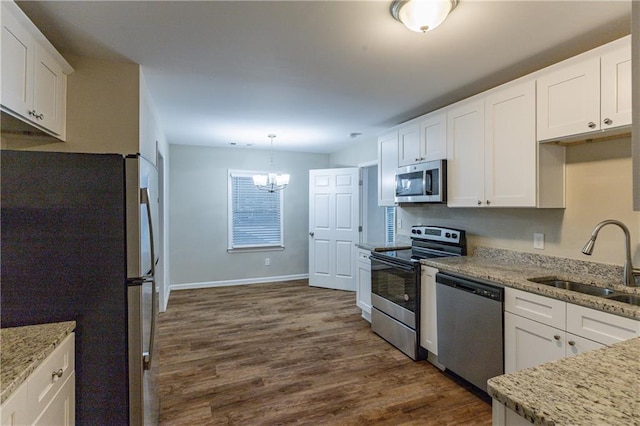 kitchen with a sink, stainless steel appliances, a notable chandelier, white cabinetry, and dark wood-style flooring