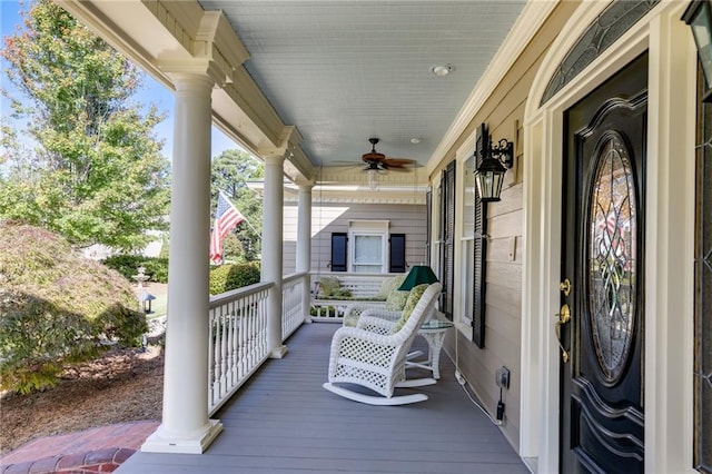 wooden deck featuring covered porch and ceiling fan