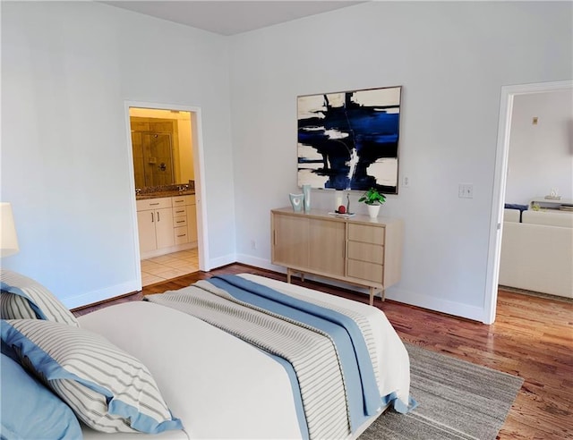 384 Ralph Mcgill Blvd NE Unit 121, Atlanta, GA 30312 - bedroom with light wood-type flooring, baseboards, and ensuite bathroom