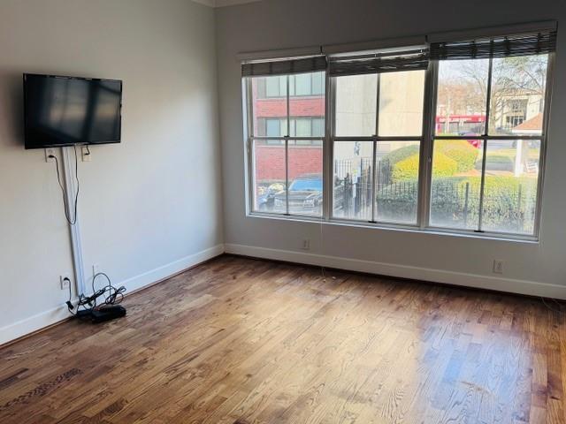 384 Ralph Mcgill Blvd NE Unit 121, Atlanta, GA 30312 - unfurnished living room with baseboards, wood finished floors, and a healthy amount of sunlight