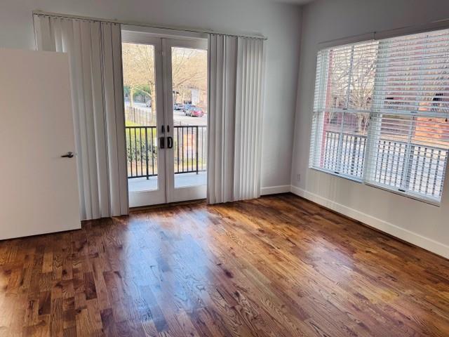 384 Ralph Mcgill Blvd NE Unit 121, Atlanta, GA 30312 - unfurnished room featuring baseboards, a healthy amount of sunlight, french doors, and wood finished floors
