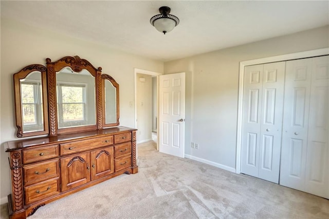 bedroom with light carpet, baseboards, and a closet