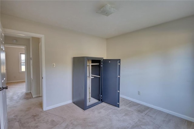 unfurnished bedroom featuring light colored carpet and baseboards