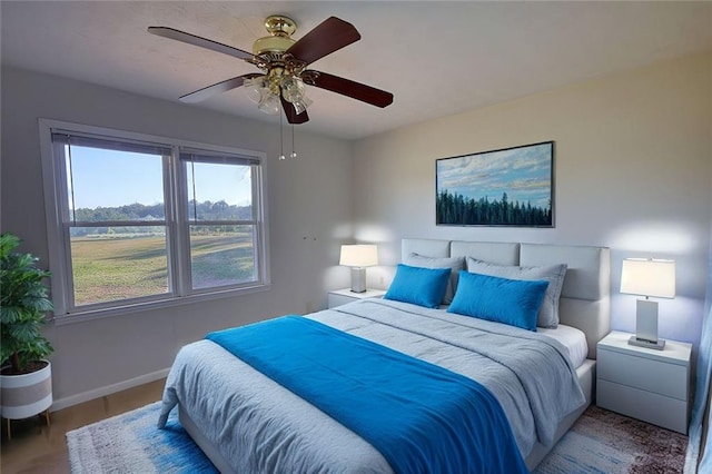 bedroom with a ceiling fan and baseboards