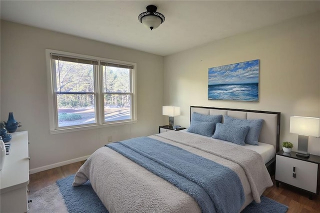 bedroom with baseboards and wood finished floors