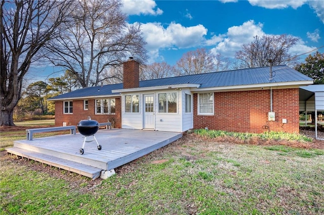 rear view of property featuring brick siding, a yard, and a wooden deck