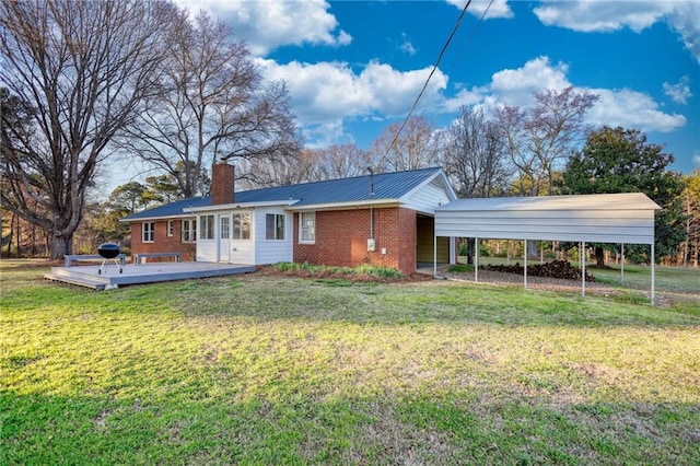 rear view of house featuring driveway, a lawn, a chimney, a deck, and brick siding