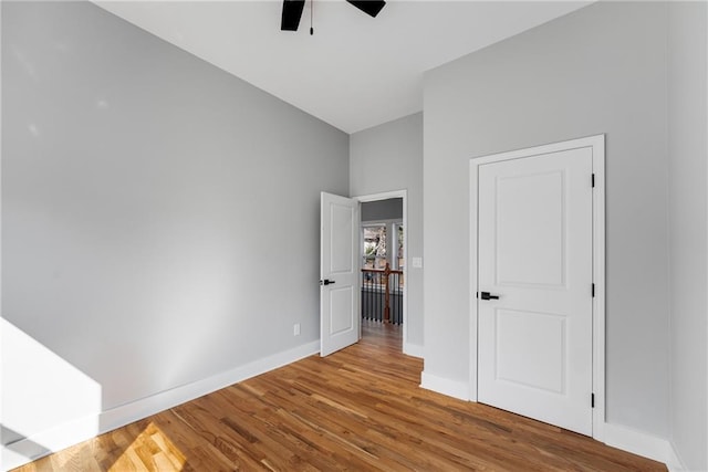 unfurnished bedroom featuring a ceiling fan, baseboards, and wood finished floors