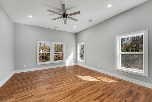 unfurnished room with wood finished floors, visible vents, and baseboards