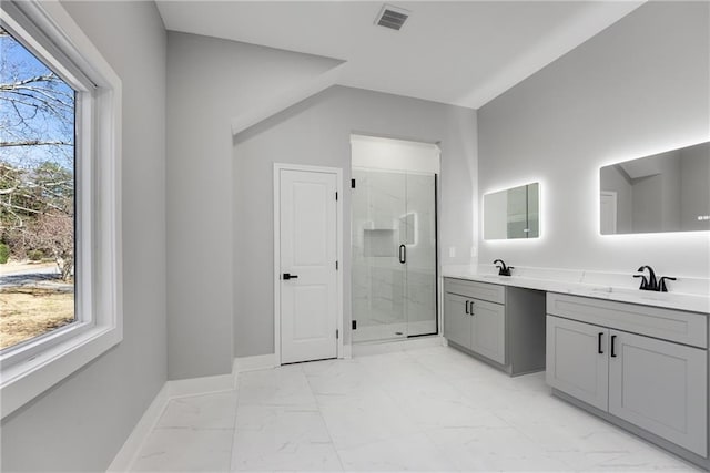 bathroom featuring marble finish floor, a stall shower, baseboards, and a sink