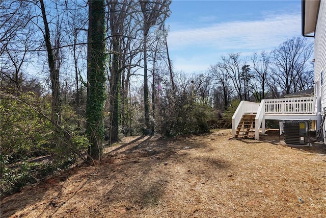 view of yard featuring stairs, central AC unit, and a wooden deck