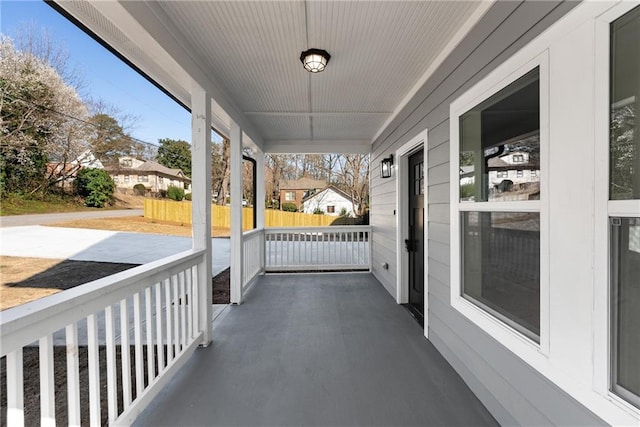 view of patio featuring covered porch and fence