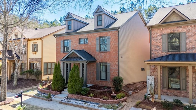 view of front of property featuring brick siding and a standing seam roof