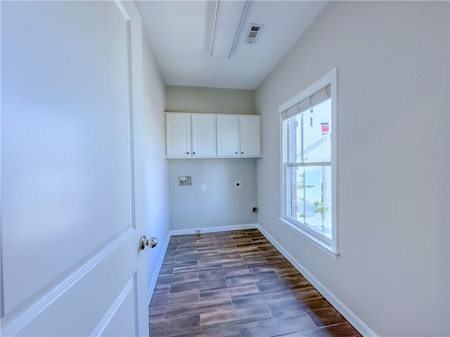 clothes washing area featuring visible vents, hookup for an electric dryer, baseboards, cabinet space, and dark wood-type flooring