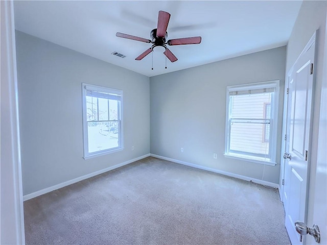 carpeted empty room featuring visible vents, baseboards, and ceiling fan