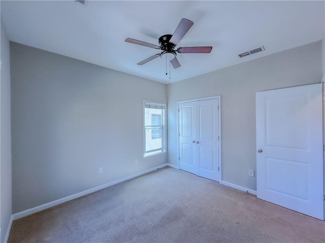 unfurnished bedroom featuring visible vents, baseboards, ceiling fan, carpet flooring, and a closet