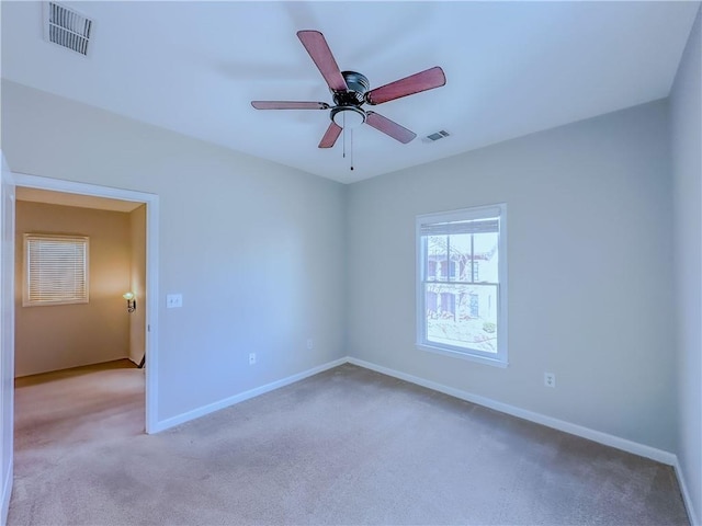 unfurnished room with visible vents, ceiling fan, carpet flooring, and baseboards