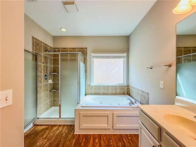 bathroom with vanity, wood finished floors, visible vents, a stall shower, and a jetted tub