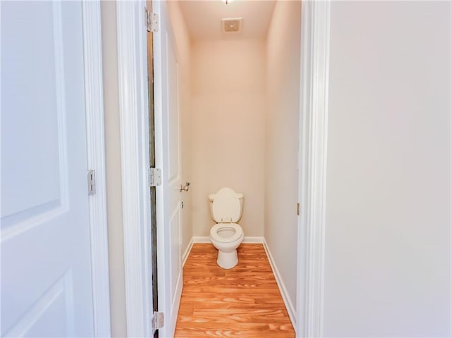 bathroom with visible vents, toilet, baseboards, and wood finished floors