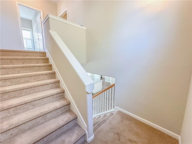 staircase with baseboards and carpet