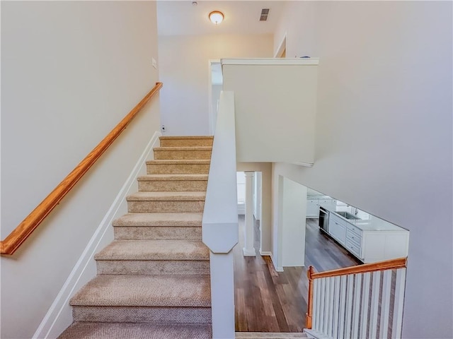 stairs with visible vents, baseboards, and wood finished floors