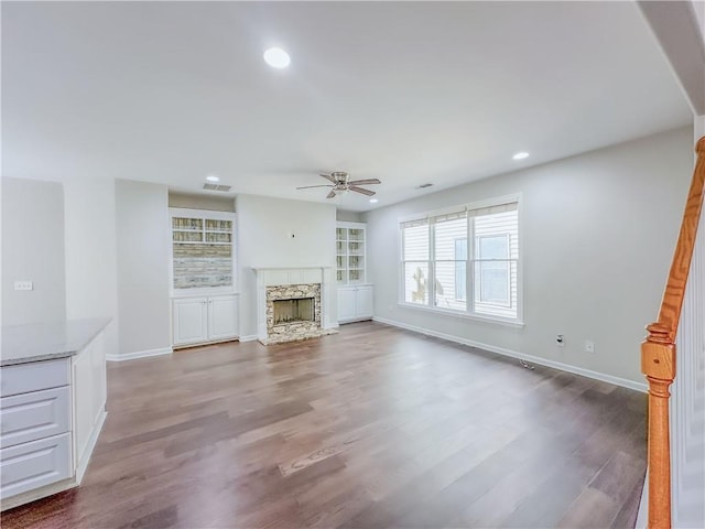 unfurnished living room with visible vents, ceiling fan, recessed lighting, a fireplace, and wood finished floors