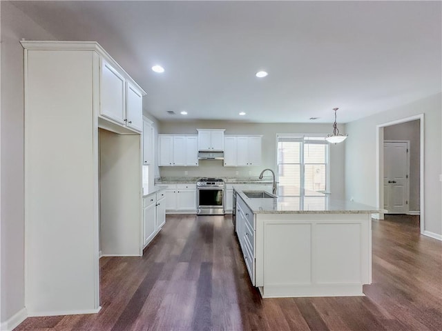 kitchen with under cabinet range hood, gas range, dark wood-style floors, white cabinets, and a sink