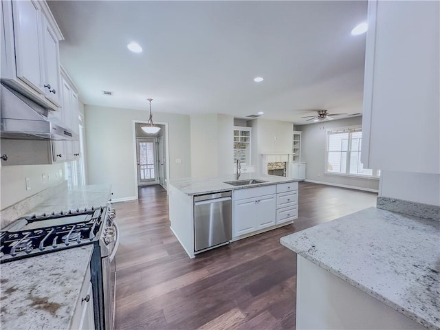 kitchen with ceiling fan, open floor plan, appliances with stainless steel finishes, white cabinetry, and a sink