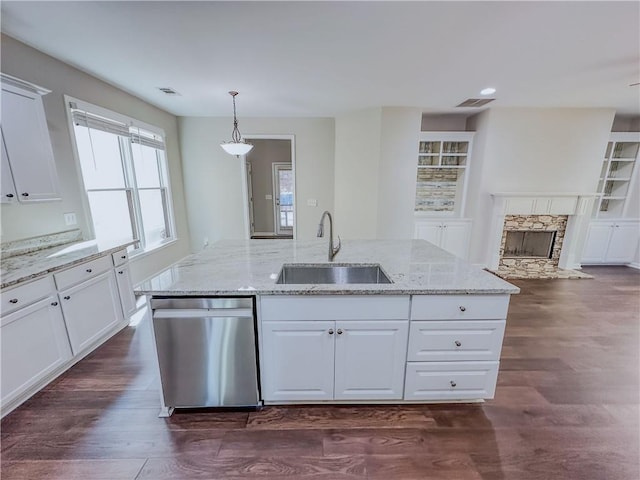 kitchen with dark wood-style floors, a center island with sink, a sink, white cabinets, and stainless steel dishwasher