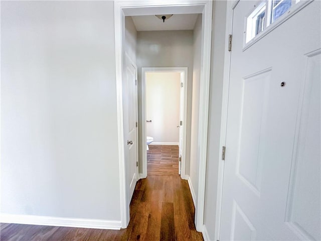 hall with dark wood-style floors and baseboards