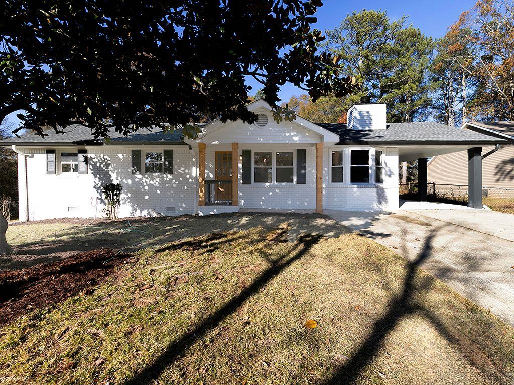 single story home featuring a front lawn and a carport