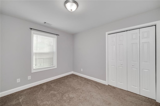 unfurnished bedroom featuring a closet and light carpet