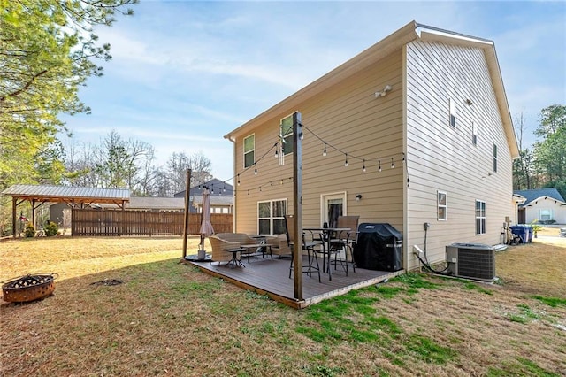 back of house featuring a wooden deck, a yard, and central AC