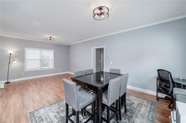 dining space featuring hardwood / wood-style flooring and crown molding